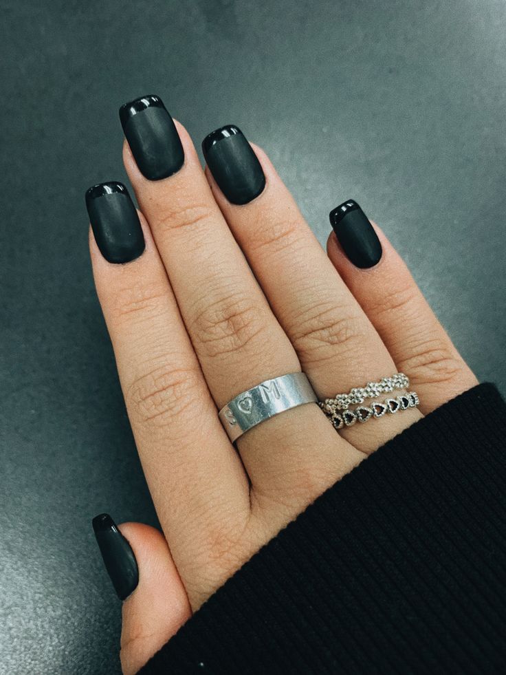 Chic Black Nails with Glossy Tips: A Modern Elegant Look Enhanced by Silver Rings.