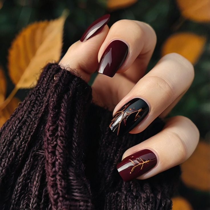 Elegant Burgundy and Black Autumn Nail Design with Gold Leaf Accents