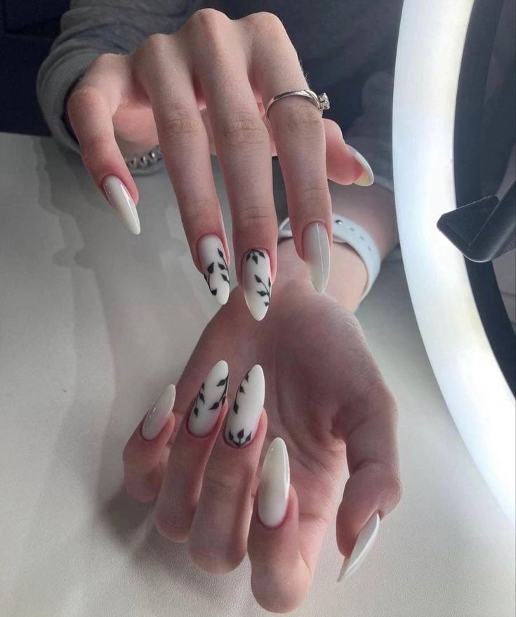 Elegant Almond-Shaped Nail Design: Glossy White with Intricate Black Patterns for a Modern Sophistication.