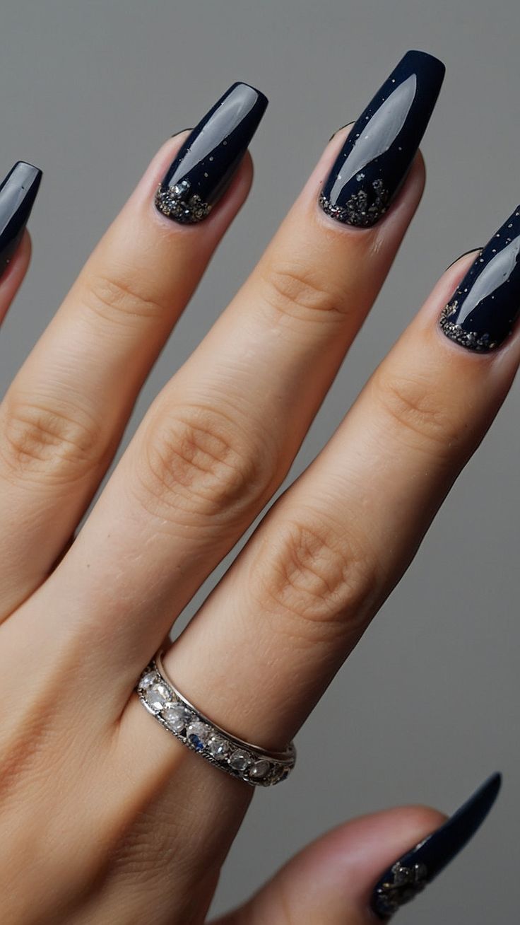 Chic Navy Almond-Shaped Acrylic Nails with Glitter Accents and Delicate Ring.