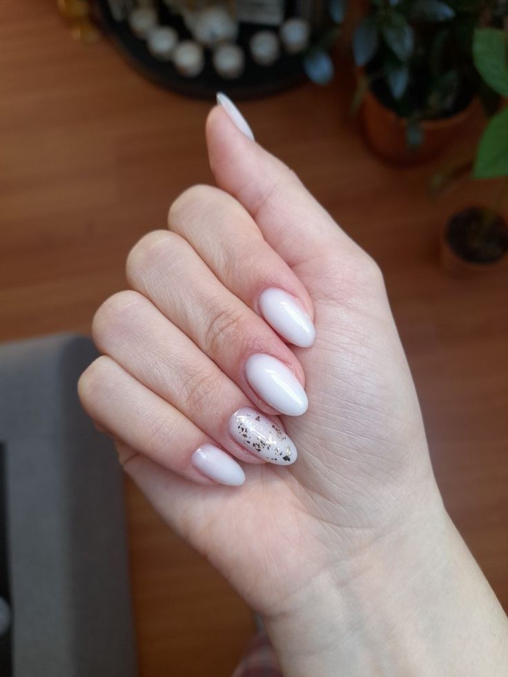 Chic Almond-Shaped Nails with Glossy White Finish and Sparkling Metallic Accent