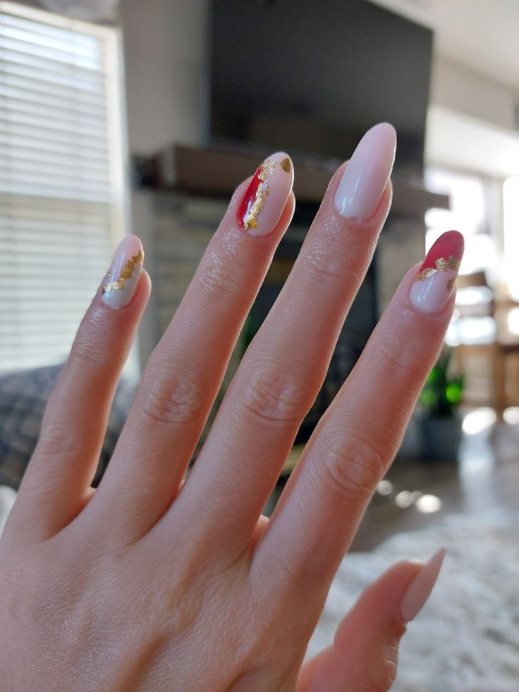 Sophisticated Nude Nail Design with Deep Red and Gold Foil Accents.