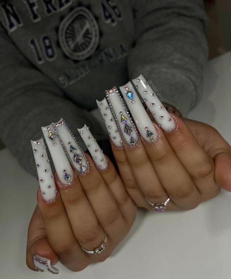 Glamorous Glossy White Acrylic Nails with Intricate Designs and Sparkling Accents.