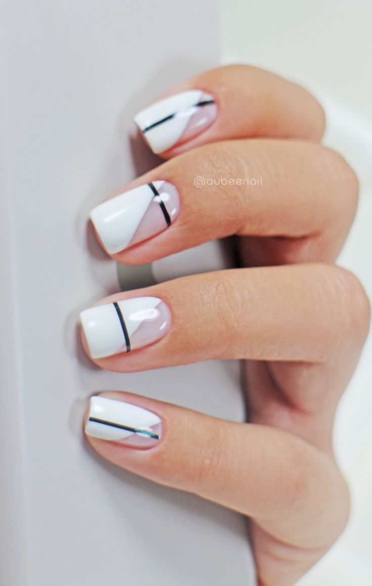 Chic Geometric Nail Design: Elegant White and Nude Tones with Bold Black Accents.