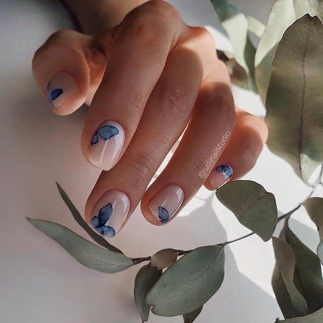 Elegant Floral Nail Art with Soft Blue Leaves and Green Foliage.