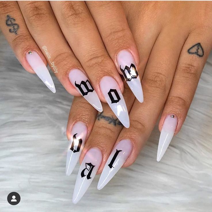 Sophisticated Gradient Stiletto Nails with Bold Black Lettering and Subtle Embellishments.