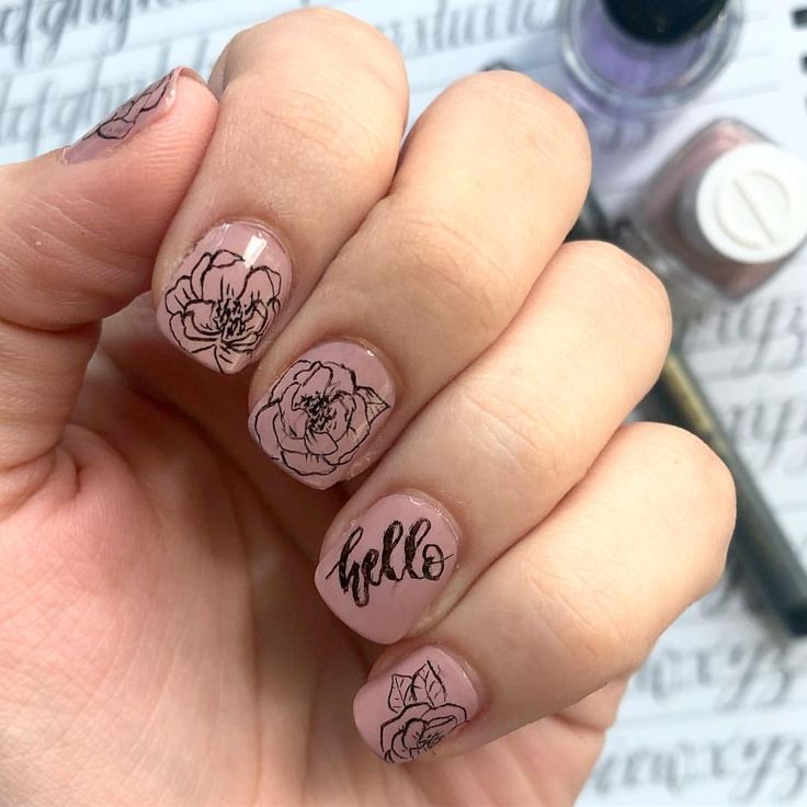 Elegant Floral Nail Art with Unique Designs on Soft Pink Base.