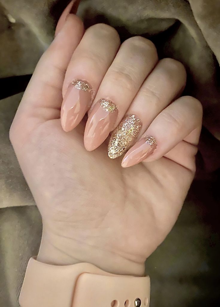 Elegant Nude Nail Design with Shimmering Gold Accents and Glossy Tips.