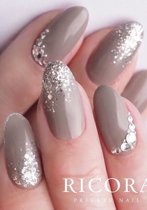 Sophisticated Taupe Nail Design with Glitter and Rhinestone Accents.