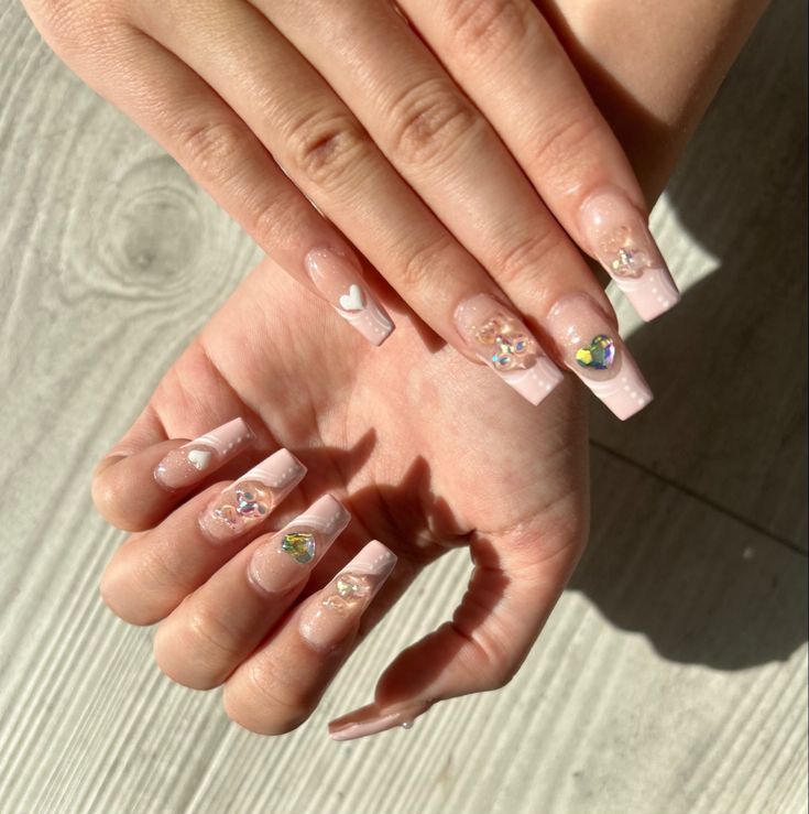 Chic Soft Pink Nail Design with Floral Accents and Playful Gem Details