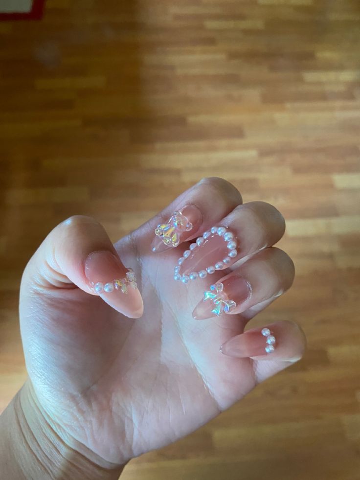 Elegant Nude Nail Design with Whimsical Pearls and Floral Accents