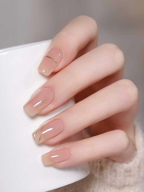 Sophisticated Soft Nude Nail Design with Gold Accents and Glossy Finish.