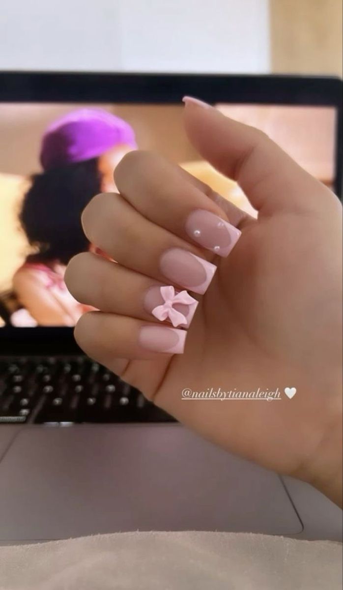 Elegant Soft Pink Nail Design with Bow and Gem Accents