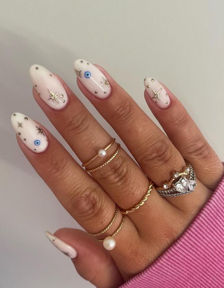 Celestial-Inspired Elegant Nail Design with Soft White Base and Almond Tips