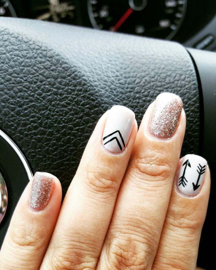 Chic Nail Design: Glitter and Minimalist Patterns with Modern Arrow and Chevron Motifs.