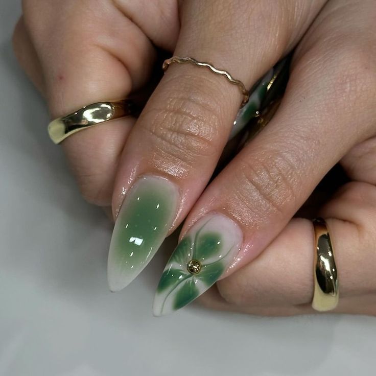 Sophisticated Ombre Green Nail Design with Floral Motifs and Gem Accents