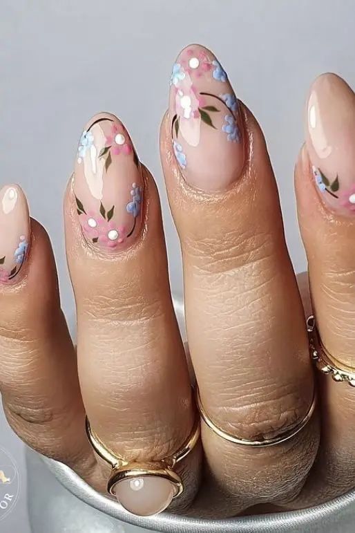 Elegant Floral Nail Art with Soft Pink and Blue Blossoms on a Nude Background.