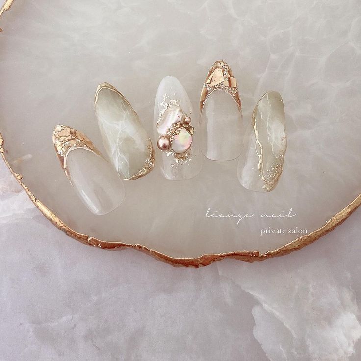 Sophisticated Nail Design Blending Translucent, Marble Finishes with Gold Accents and Gemstones.