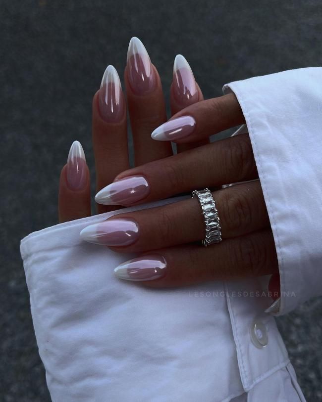 Elegant Almond-Shaped Gradient Nails: From Soft Nude to Crisp White with Silver Ring Accents.