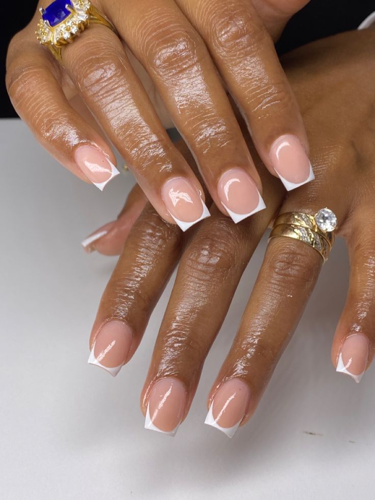 Chic French Tip Nail Design with Soft Nude Base and Stylish Ring Accents.