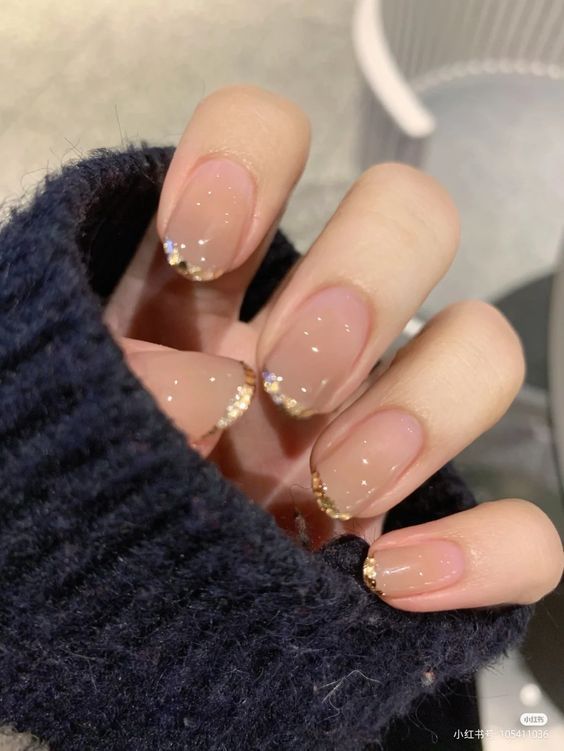 Chic Nude Nail Design with Subtle Gold Glitter Gradation