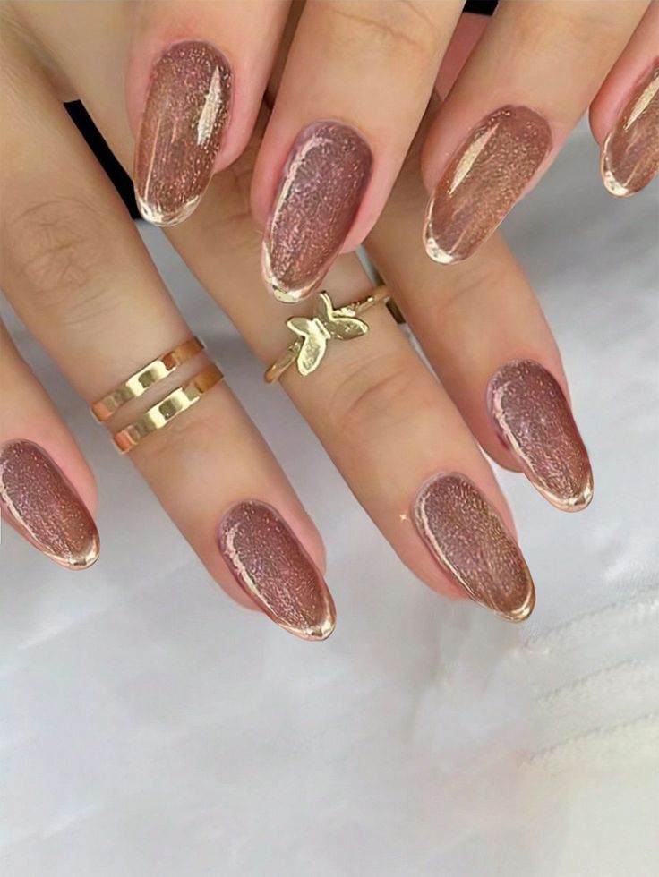 Sophisticated Rose Gold Nail Design with Delicate Gold Tips and Stylish Rings.