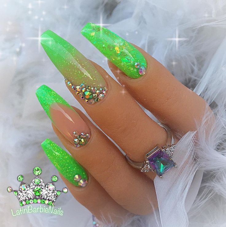 Bold Vibrant Green Stiletto Nail Design with Shimmering Gradient and Decorative Crystals.