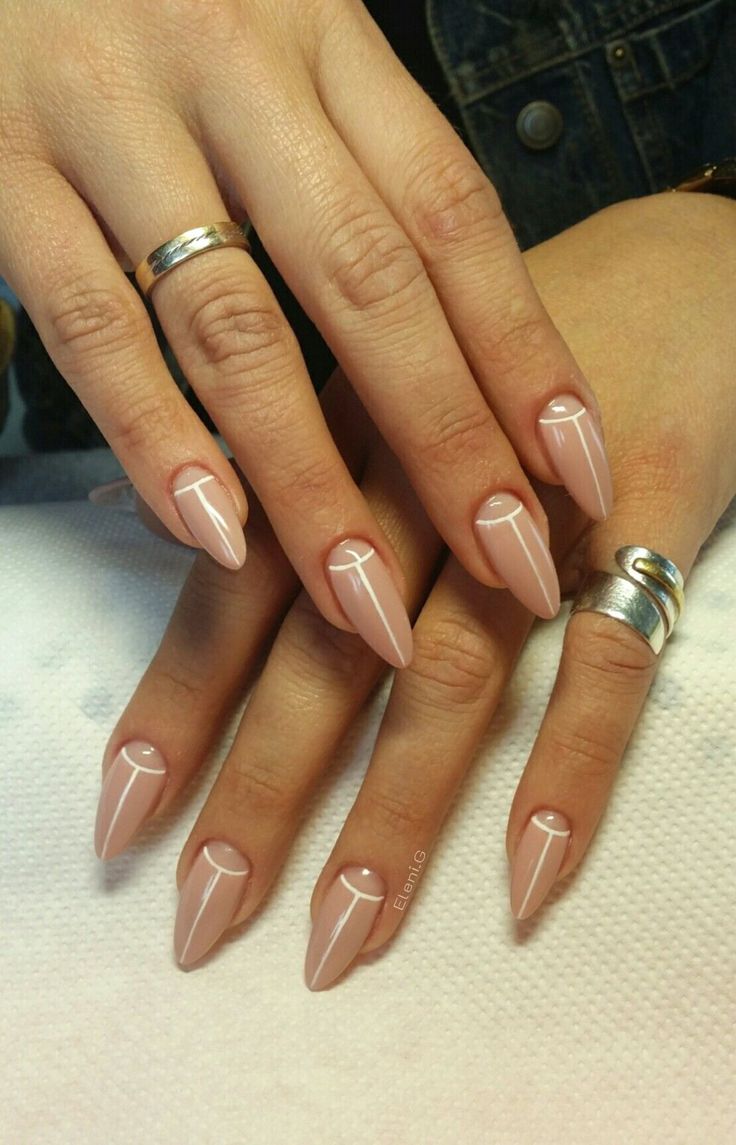 Chic Almond-Shaped Nails with Nude Polish and Geometric Designs for a Sophisticated Look.