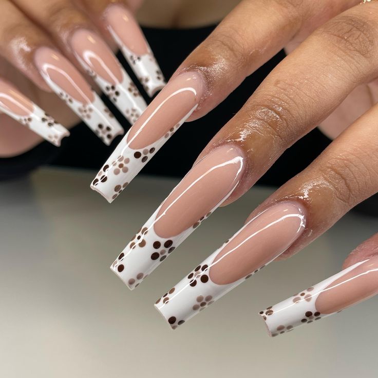 Chic Long Squared Nude Nails with Glossy White Tips and Delicate Brown Floral Accents.