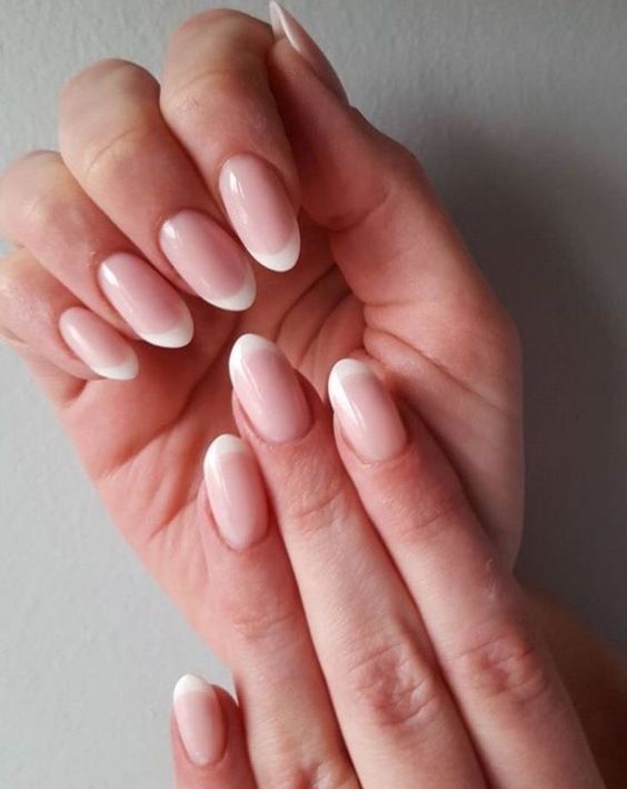 Sophisticated French Tip Manicure with Soft Pink Base and Almond Shape.