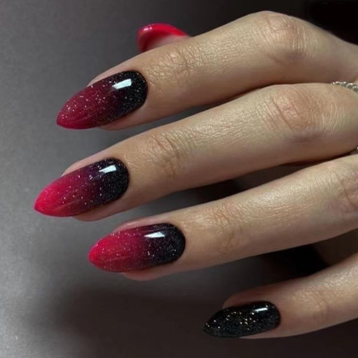 Elegant Ombre Nail Design: Striking Deep Red and Glossy Black in Stiletto Shape.