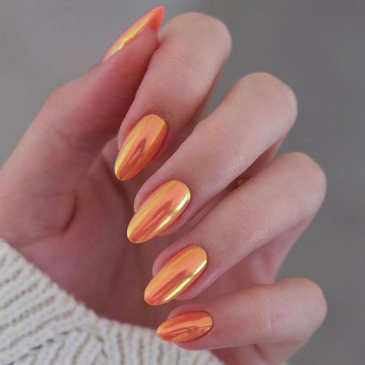 Stunning Reflective Metallic Orange Almond Nails for an Elegant Pop.