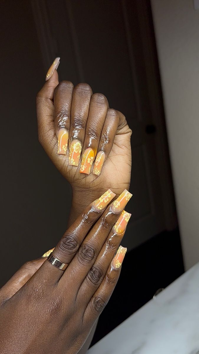 Bold Orange and Yellow Gradient Nail Design with Floral Accents on Square Nails