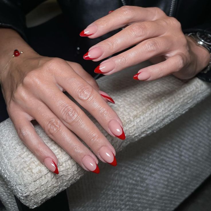 Sophisticated Nude Manicure with Bold Red Tips for a Contemporary Look.