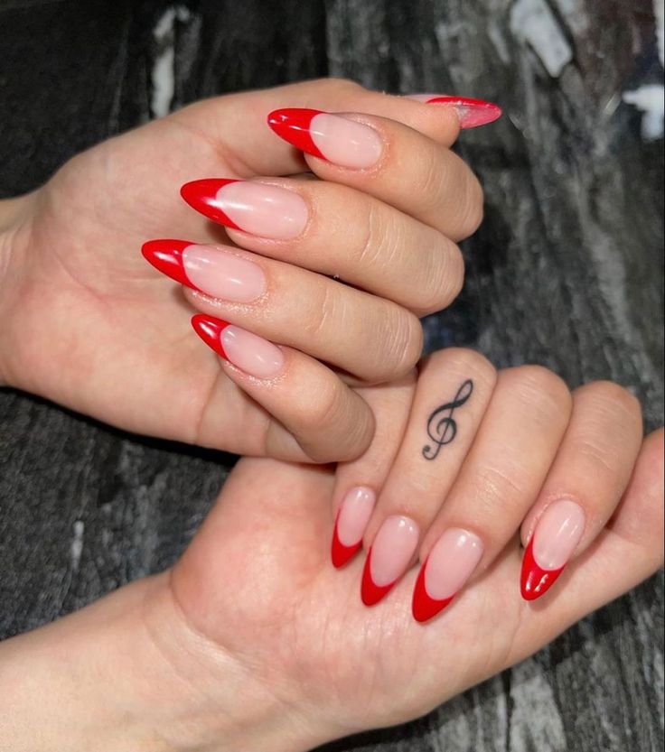 Chic Red French Tip Nail Design with Musical Note Tattoo for a Bold and Creative Look.