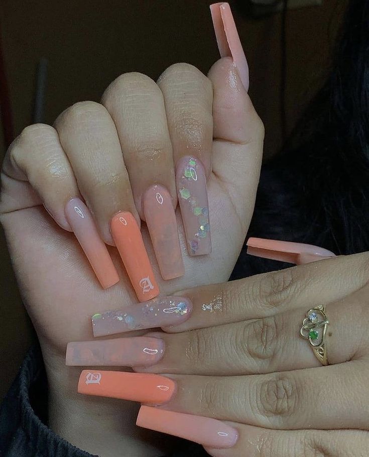 Elegant Colorful Nail Design with Soft Peach and Nude Tones and Chic Embellishments.