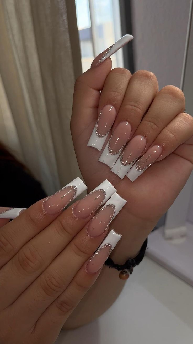 Chic Nude and White Nail Design with Glamorous Tapered Shape and Embellishments.