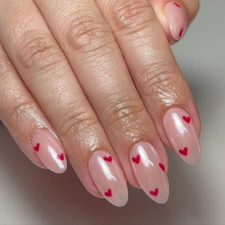 Charming Playful Heart Nail Design: Soft Nude Base with Red Accents for a Romantic Touch.