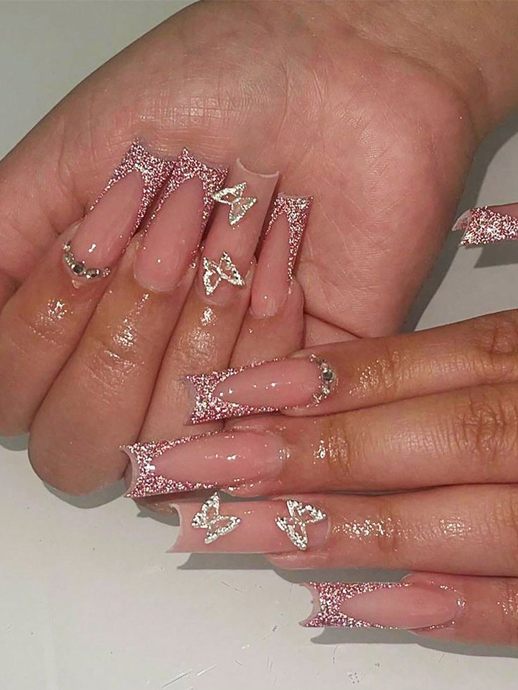 Elegant Nude Nail Design with Glittery Tips and Butterfly Accents