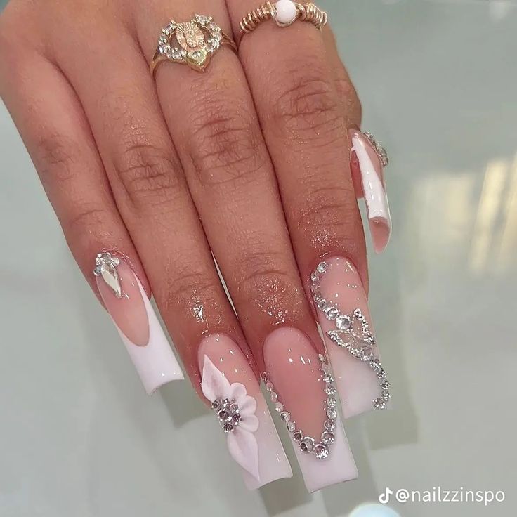 Chic Elegance: White and Nude Long Nails with Floral Embellishments and Rhinestones.