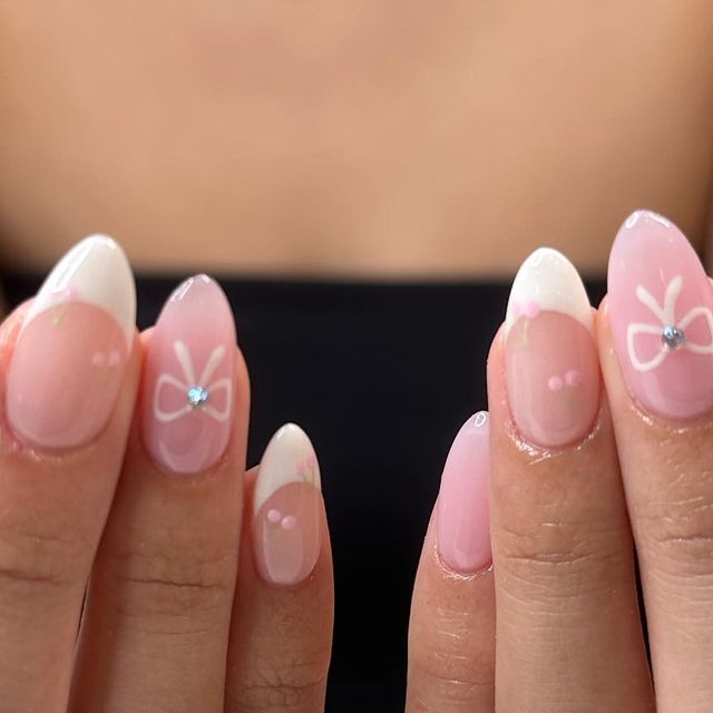 Elegant Pastel Pink Nails with French Tips and Bow Designs Featuring Rhinestones