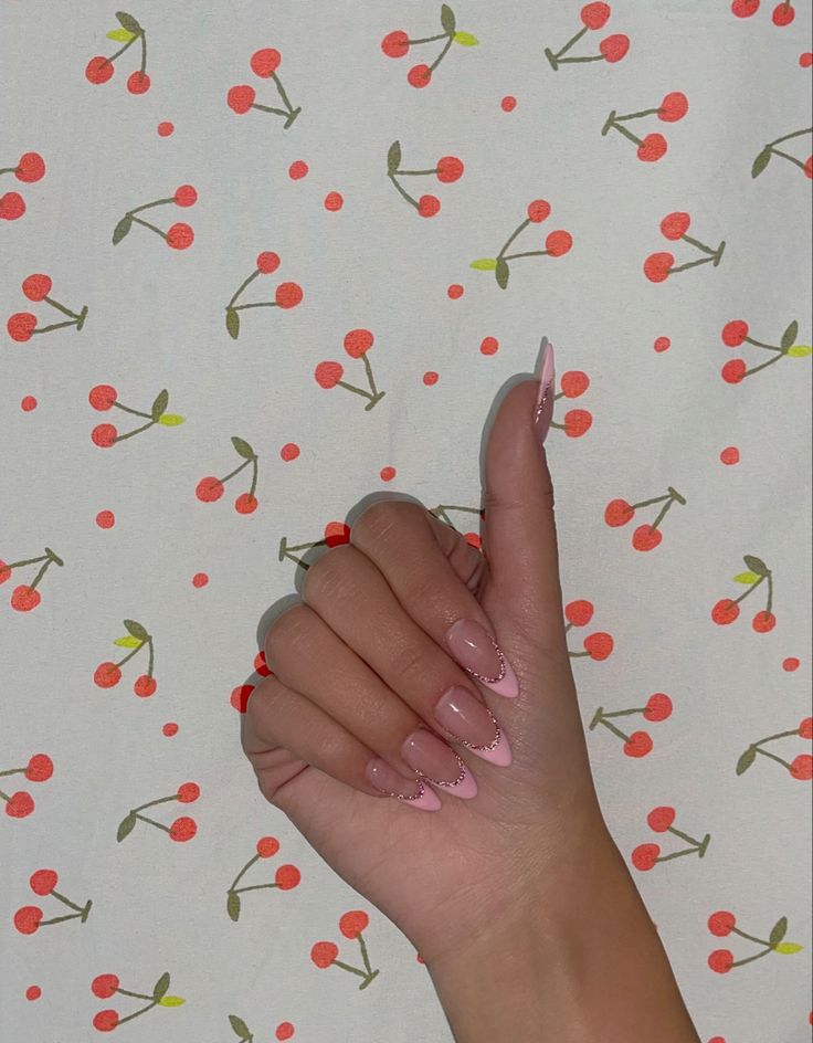 Chic Almond-Shaped Nail Design with Soft Pink Base, White Tips, and Vibrant Red Accents on Cherry-Patterned Background.