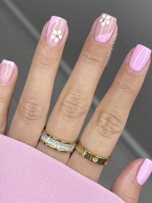 Charming Floral Pink Nail Design with Delicate Accents and Elegant Rings