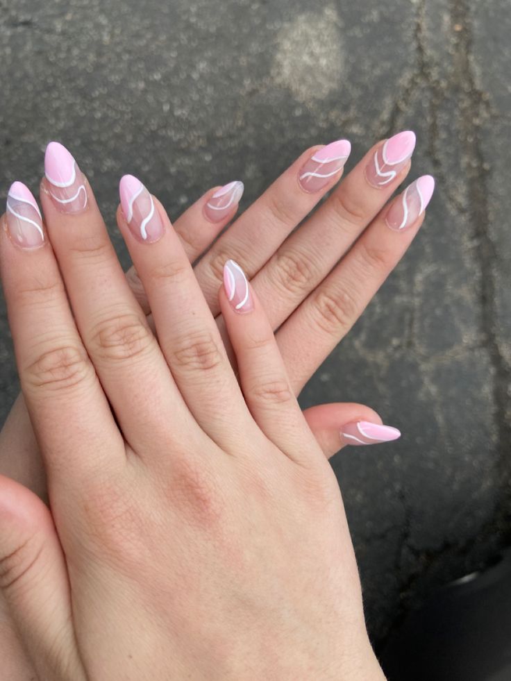 Elegant Almond-Shaped Nails: Soft Pink Base with Artistic White Swirls for Stylish Versatility.