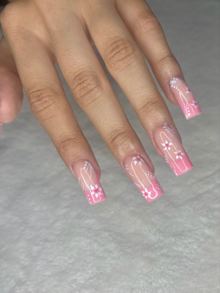 Elegant Soft Pink Gradient Nail Design with Floral Accents and Glossy Finish.