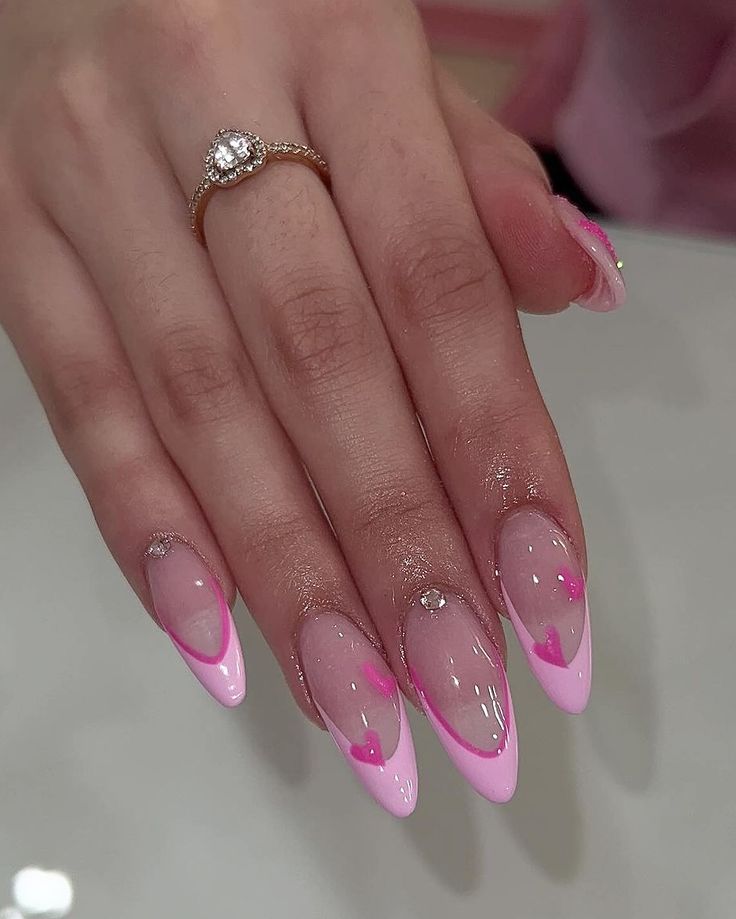 Chic Pastel Pink Ombre Stiletto Nails with Heart Motifs and Sparkling Accents for Special Occasions.