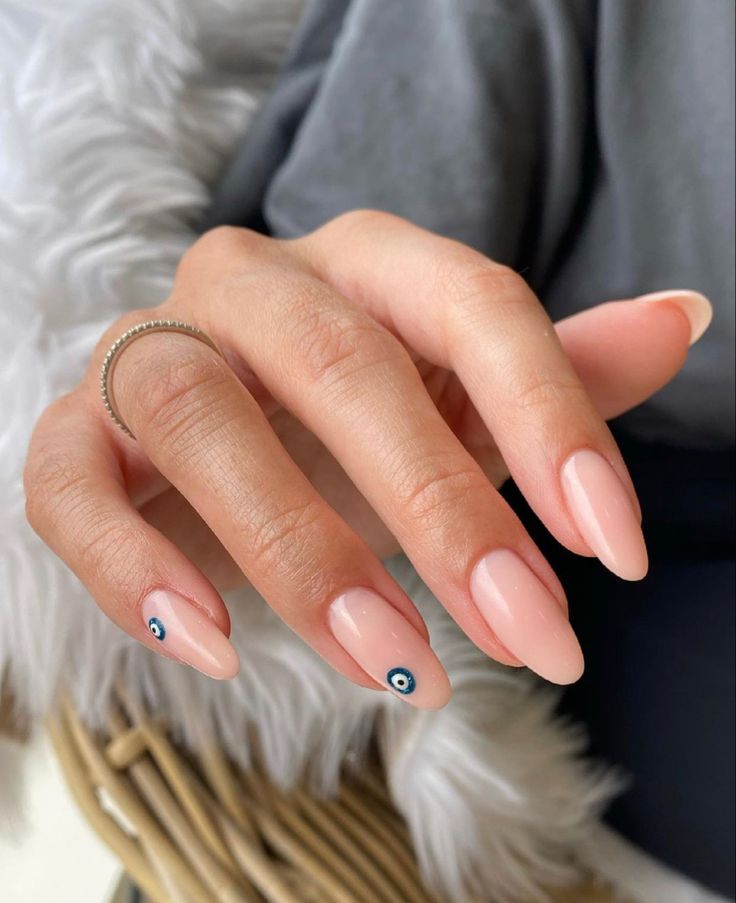 Chic Almond-Shaped Nails with Nude Polish and Playful Eye Motifs