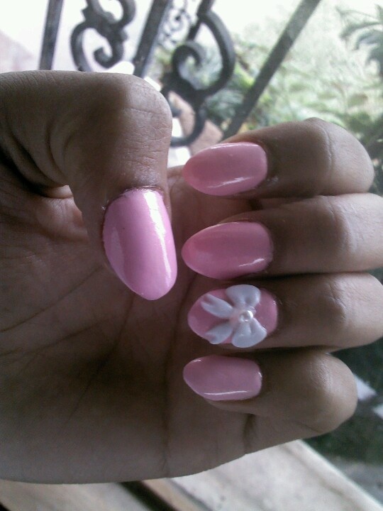 Charming Pink Nail Design with Glossy Finish and Textured White Flower Accent.