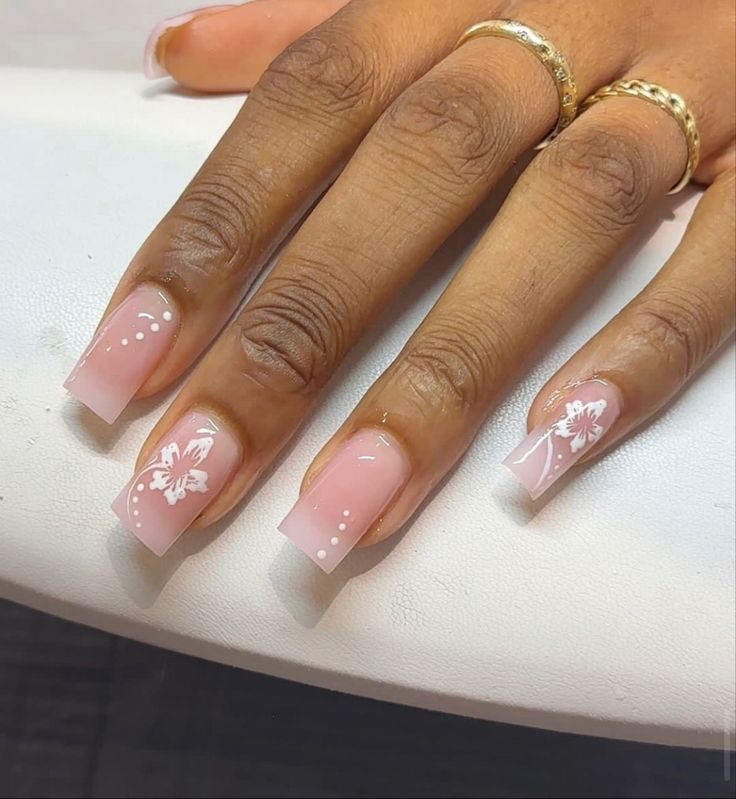 Sophisticated Soft Pink Gradient Nail Design with White Floral Accents.