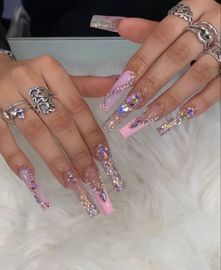 Elegant Nail Design with Elongated Acrylic Tips, Holographic Glitter, and Gemstone Embellishments.